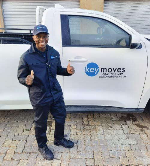 PProfessional Key Moves delivery driver giving thumbs up beside a key moves branded truck outdoors.